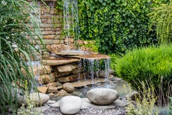 A small decorative waterfall in the garden. Landscape design
