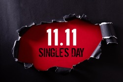 Online shopping of China, 11.11 single's day sale concept. Top view of Black torn paper and the text 11.11 single's day sale on a red background.