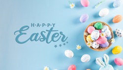 Happy easter! Colourful of Easter eggs in the nest with rabbit on pastel blue background. Greetings and presents for Easter Day celebrate time. Flat lay ,top view.