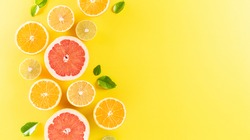 Summer composition made from oranges, lemon or lime on pastel yellow background. Fruit minimal concept. Flat lay, top view, copy space.
