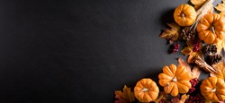 Autumn background decoration from dry leaves and pumpkin on dark wooden background. Flat lay, top view for Autumn, fall, Thanksgiving concept.