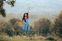 Happy Woman Jumping in Countryside Rural Landscape
Farm girl wearing denim overall appreciating simple life
