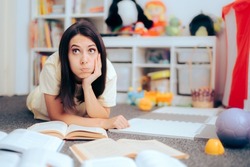 
Woman Studying in a Playroom with Textbooks on the Floor. Busy mom reading many textbooks ready getting ready for an exam
