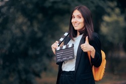 
Happy Actress Holding Thumbs Up Ready to Film New Scene. Cheerful acting student holding a film slate
