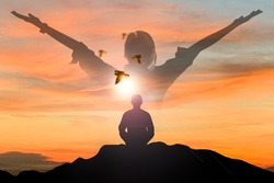 Silhouette of young asian man practices yoga and meditates on top of the mountain with double exposure young man standing and open arm and feel free with bird over the sky at sunset in summer season. 