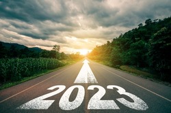 New year 2023 or straight forward concept. Text 2023 written on the road in the middle of asphalt road with at sunset. Concept of planning, goal, challenge, new year resolution.
