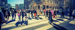 Busy Pedestrian Crossing over zebra on sunny day in the city 
