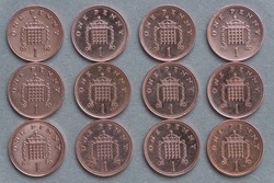 Used one penny British coins on grey background. Close up view from above.