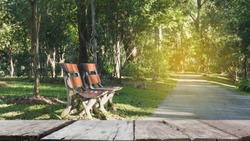 blur image of wood bench for resting and relaxing beside walkway in the park with selected focus empty wood table for display your product