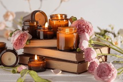 A set of different aroma candles in brown glass jars. Scented handmade candle. Soy candles are burning in a jar. Aromatherapy and relax in spa and home. Fire in brown jar.