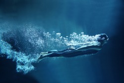 professional swimmer underwater in abyss isolated on blue background