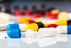 Antibiotics contain blue pills, yellow-red or capsules on a white background with copied clearance. Medication in healthy containers, antibiotics and dangerous drugs.