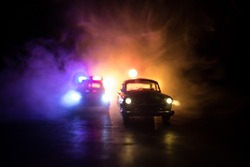 Police car chasing a car at night with fog background. 911 Emergency response police car speeding to scene of crime. Selective focus