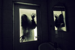 Horror woman in window wood hand hold cage scary scene halloween concept Blurred silhouette of witch