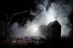 Scary view of zombies at cemetery dead tree, moon, church and spooky cloudy sky with fog, Horror Halloween concept. Toned