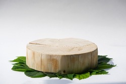 one round cut wooden platform on green leaves background, geometric podium, pedestal, mock up, eco scene for presentation of beauty products