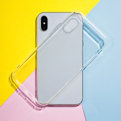 Clear iPhone case mock up. Smart phone on a background of pink, yellow and blue paper, silicone transparent case back view mockup