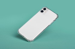 White iPhone 11 in clear silicone case falls down. Smart phone case mock up back view isolated on green background iPhone 12