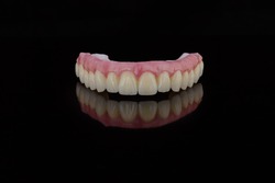 High-quality dental prosthesis made by dental technician, prosthesis with a pink gingiva to fix after implantation.