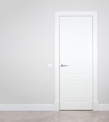 Modern white door. Grey wall with free space. Minimalist bright interior