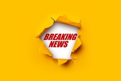 Bright yellow torn paper inside in a hole Breaking news on a white background 