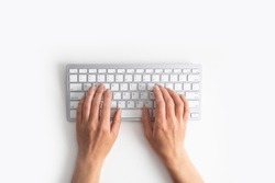 Female hands on the keyboard on a white background. Top view, flat lay.