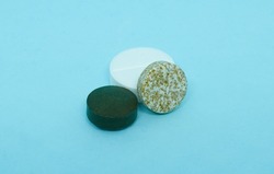 Green, white and mottled tablets lie on a blue background