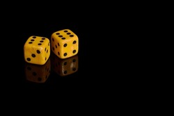 Gambling. Two dice on a black background with reflection, copy space