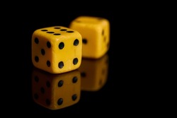 Gambling. Two dice on a black background with reflection, copy space. Horizontal format