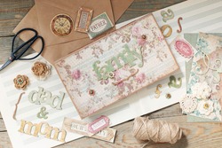 Scrapbooking. On a wooden background, a girl makes a photo album for a family in a vintage style. Top view
