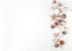 Christmas composition on a white background of Christmas decorations. Cinnamon sticks, orange chips, wooden sleigh, snowflakes, fake snow, star, deer. The view from the top.