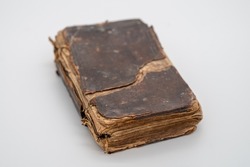Old Brown Leather Book Sitting Closed With The Leather Cover Showing Wear And Age. The pages of the book are visible from the bottom. The book sits in the middle of the frame.