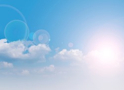 Blue sky with white clouds and bright sun with highlights. Blurred Gaussian background. Background, texture