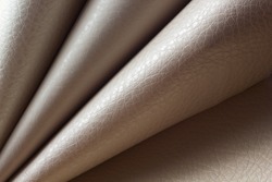 Rolls of genuine leather. Materials for the leather industry. Leather beige shades in rolls. Different skin samples. Beige, light brown natural leather.