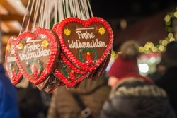 Merry Christmas written in German on gingerbread hearts at a Christmas market close up
