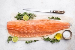 Fresh raw salmon or trout sea fish fillet with spices and herbs on white background, top view