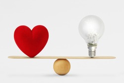 Heart and light bulb on scale - Concept of balance between heart and brain