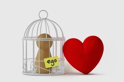 Pawn in a bird cage with the word Ego written on paper note and free heart  - Love and ego concept