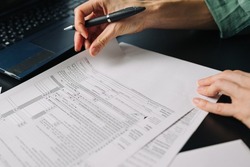 Woman filling US tax form 1040. tax form us business income office hand fill concept. Closeup