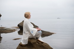 Women practicing Taijiquan in beautiful nature. Meditation in morning day on the sea coast
