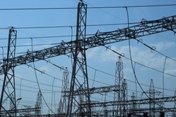 High voltage transmission towers, where many wires, have a clear sky background. View of electric towers. Pillar of high-voltage wires against the blue sky. High voltage wires.
