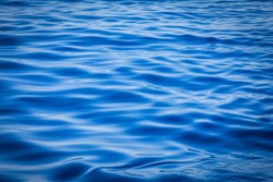 Beautiful vivid blue ocean close up image showing the ripples and reflection on the surface of the ocean on a calm day