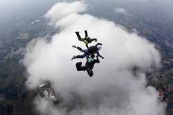 Aff instructors with student over a big cloud in free fall