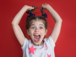 portrait of crazy little girl on red background