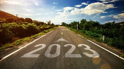 2023 written on highway road in the middle of empty asphalt road and beautiful blue sky. Concept for vision new year 2023.