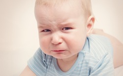 Eight month old baby crying. Sad child portrait