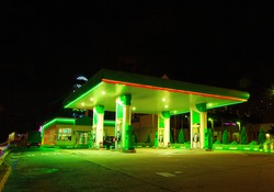 Petrol gas station station at night with lights on and mini-mart 