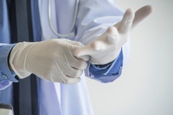 Doctor Surgeon putting on white sterilized surgical glove  in hospital operating room