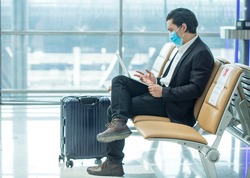 Asian passenger businessman wear masks covid19 disease prevention and Teleconference with laptop while traveling to work abroad at the airport terminal.New normal and Business trip concept
