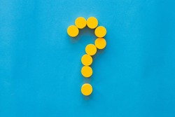 Yellow dot make question mark sign on cyan background.